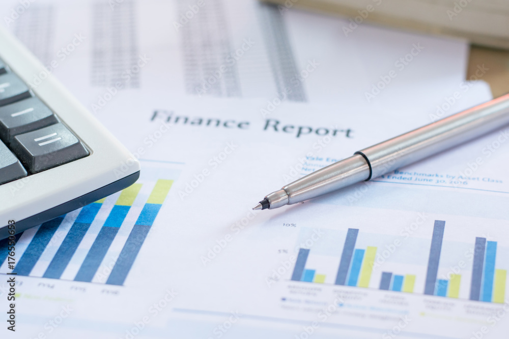 Close up pen on finance report and calculator on table office. Close up pen on finance report and calculator on table office.