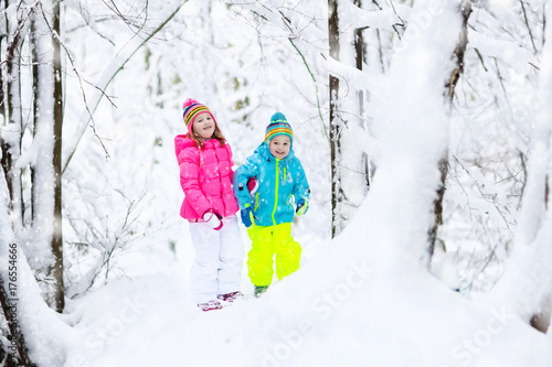 Kids playing in snow. Children play outdoors in winter snowfall.