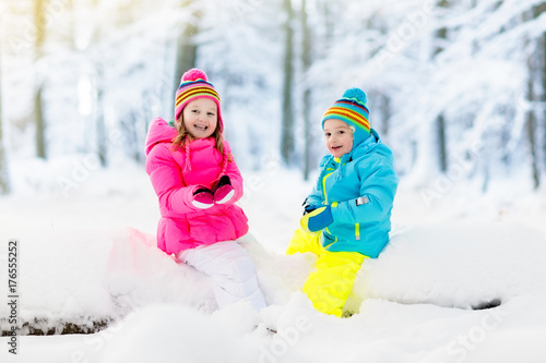 Kids playing in snow. Children play outdoors in winter snowfall.