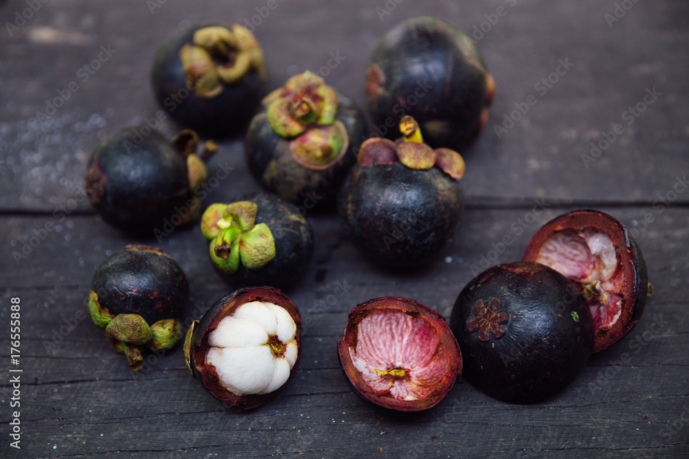 Several purple mangosteens on a wooden table Several purple mangosteens on a wooden table