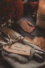 Thanksgiving decoration with cutlery and napkin on the wooden table, close up