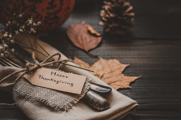 Thanksgiving decoration with cutlery and napkin on the wooden table, close up