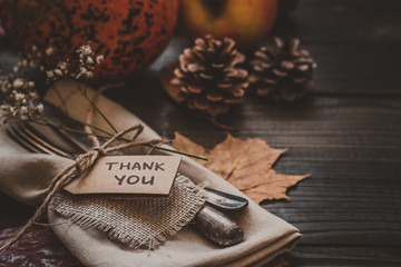 Thanksgiving decoration with cutlery and napkin on the wooden table, close up
