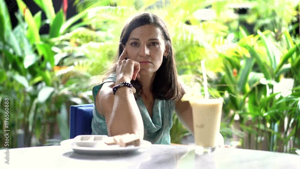 Attractive woman sitting in exotic restaurant and doing serious look to the camera, steadycam shot
Attractive woman sitting in exotic restaurant and doing serious look to the camera, steadycam shot