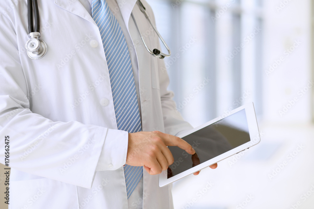 Doctor using a digital tablet, close-up of hands. Health care concept Doctor using a digital tablet, close-up of hands. Health care concept