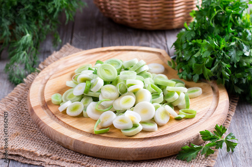 Leeks chopped in rings on wooden chopping board photo