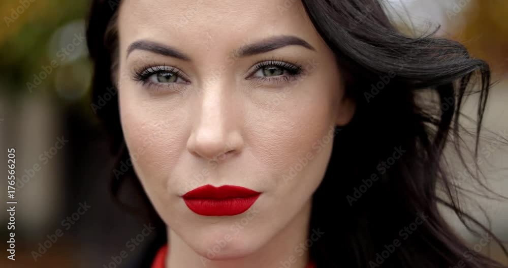 Attractive woman with vivid makeup with serious look posing for camera on blurry background of autumn park. Attractive woman with vivid makeup with serious look posing for camera on blurry background of autumn park.
