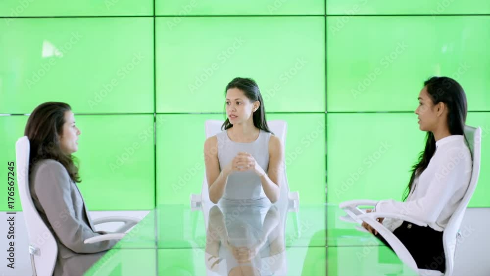 Female corporate business team in a meeting with green screen wall behind Female corporate business team in a meeting with green screen wall behind