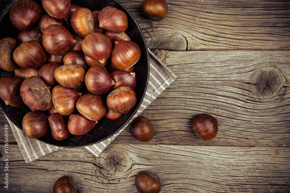 chestnuts in a pan on a wooden background chestnuts in a pan on a wooden background
