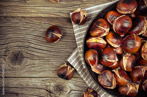 chestnuts in a pan on a wooden background