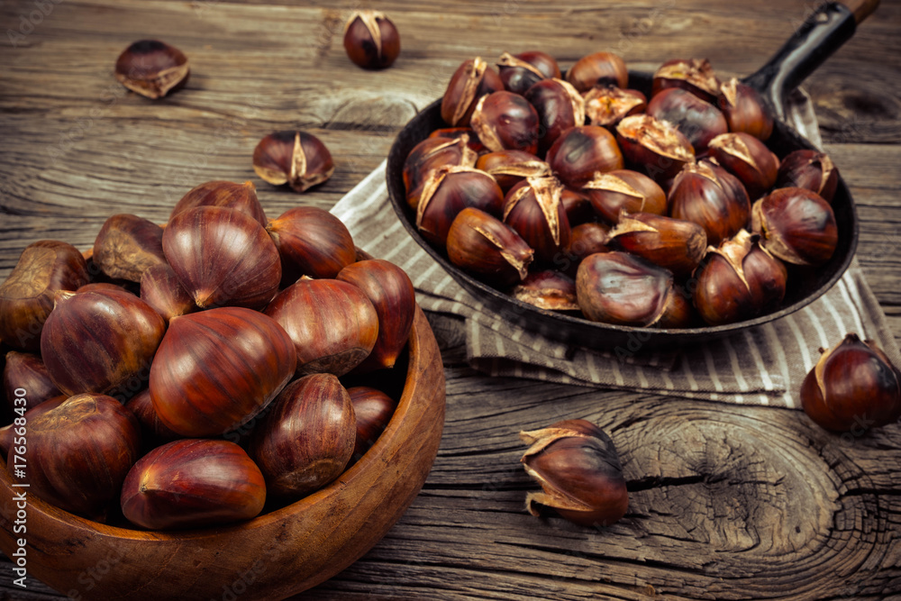 chestnuts in a pan on a wooden background chestnuts in a pan on a wooden background