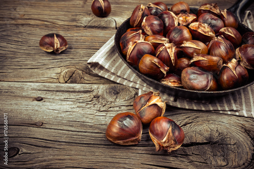 chestnuts in a pan on a wooden background photo