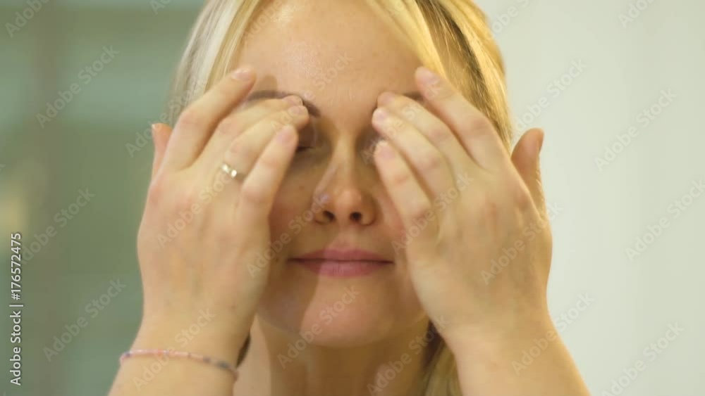 Blonde gently makes herself a facial massage Blonde gently makes herself a facial massage