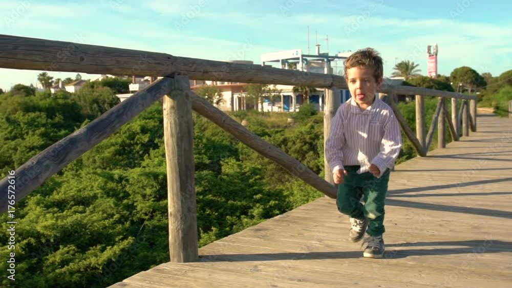 Slow video of Happy kid running and playing on the beach Slow video of Happy kid running and playing on the beach