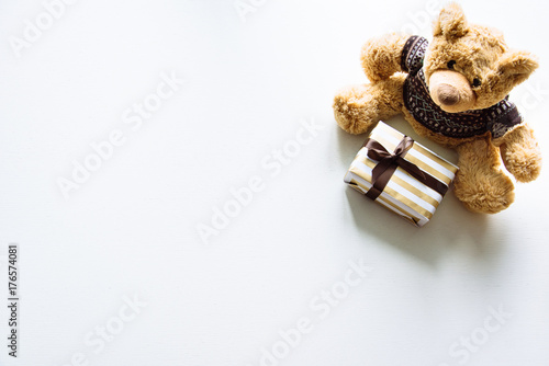 Nice cute funny toy background. Present for small kids on a birthday party. Best friend for little boys and girls. Funny attractive pretty soft bear with a present box. Background for children.