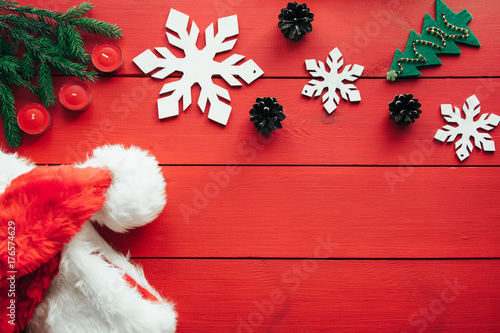New year's background on a red desk decorated with toys, presents, Christmas tree, candles. Bright colored background symbolizes the new year celebration. Great useful template to wright words down.