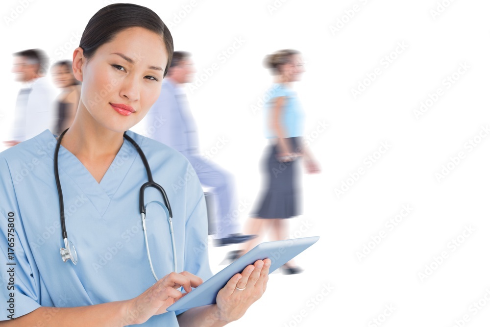 Composite image of surgeon using digital tablet with group Composite image of surgeon using digital tablet with group