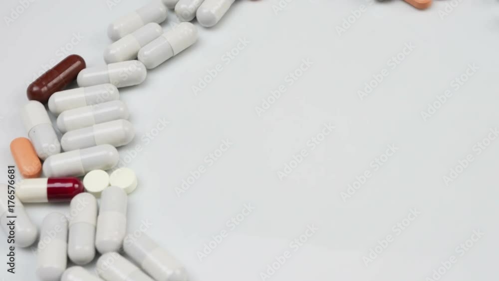 Close up, with red, white, colored pills rotating, from the left side Close up, with red, white, colored pills rotating, from the left side