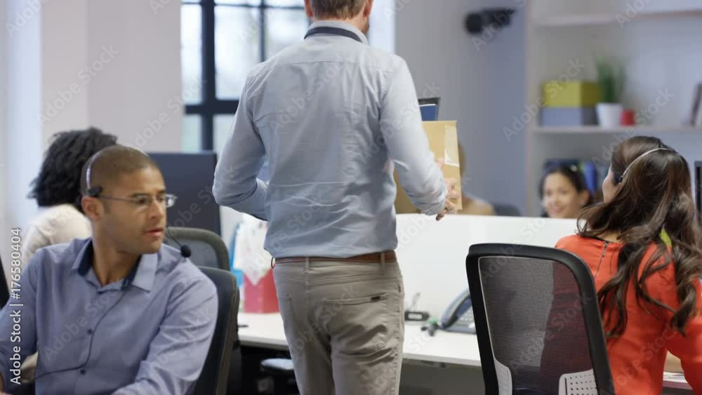 Happy businessman starting new job unpacking his belongings at his desk Happy businessman starting new job unpacking his belongings at his desk