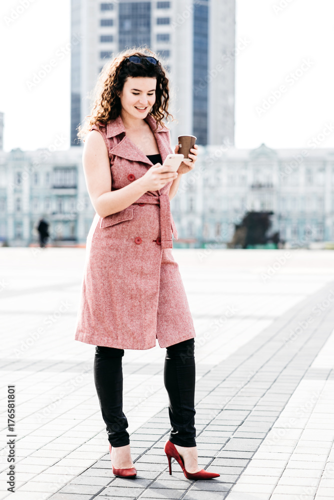 Beautiful girl standing with coffee on the street