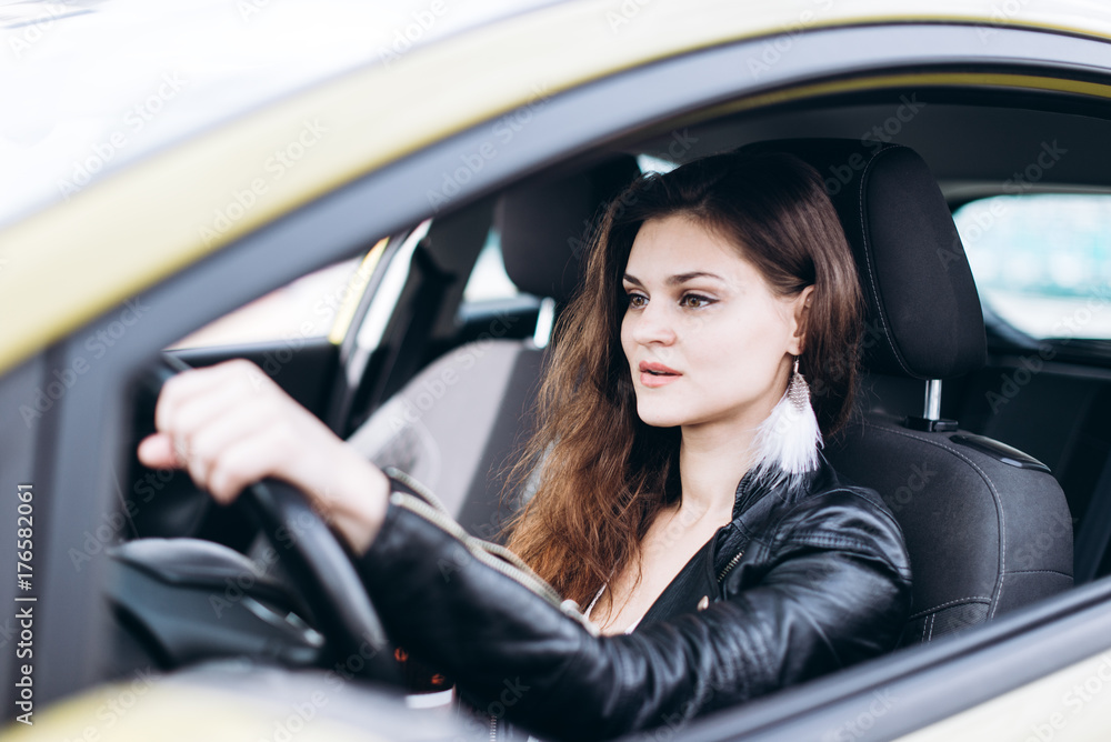 Young beautiful girl driving a car