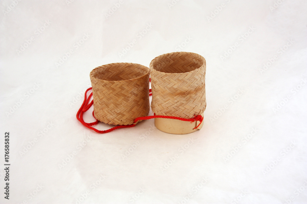 Sticky rice basket open the container with red hanging string on white background. Sticky Rice Serving Basket Classic Laos and Thai Asian Steamer Food Container Bamboo. Sticky rice basket open the container with red hanging string on white background. Sticky Rice Serving Basket Classic Laos and Thai Asian Steamer Food Container Bamboo.
