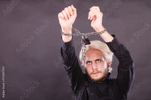 Furious man with chained hands, no freedom