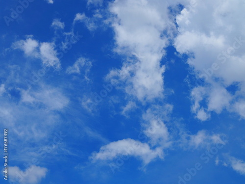 Blue bright sky with white big spread clouds at the upper right corner  abstract shape background