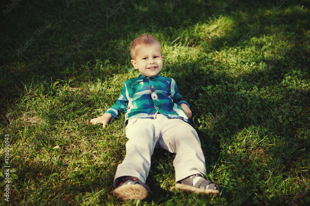 Little boy having fun playing in the Park on the grass Little boy having fun playing in the Park on the grass