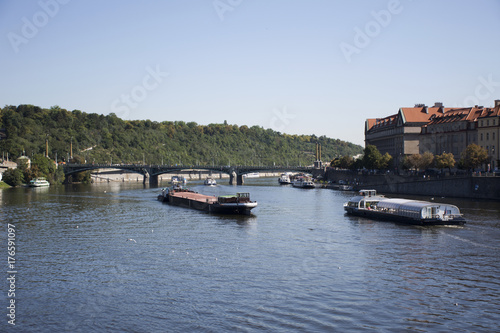 Barge and Tugboat cargo ship and River Cruises sailing in Vltava river near Charles Bridge