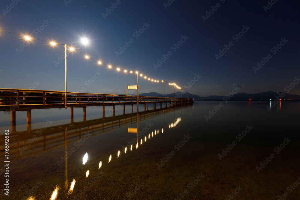 Jetty at night with full moon at Lake Chiemsee, Seebruck, Bavaria, Germany, (Translation sign: Steamer jetty, Departure to Islands)