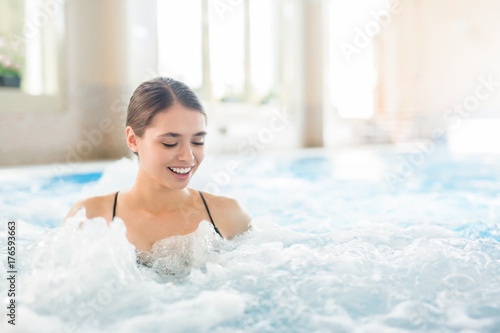 Fotografie Young woman enjoying warm gentle water waves in whirlpool