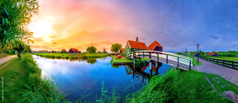 Traditional village at sunset, with dutch windmills, bridge and river on Zaanse Schans, Holland, Netherlands.