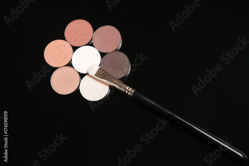 Professional make up set of cosmetics, flower shape eyeshadow close up. Strobing and contouring beauty concept
