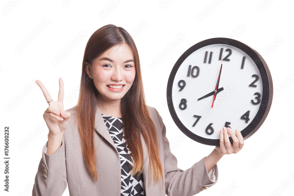 Young Asian business woman show victory sign with a clock. Young Asian business woman show victory sign with a clock.