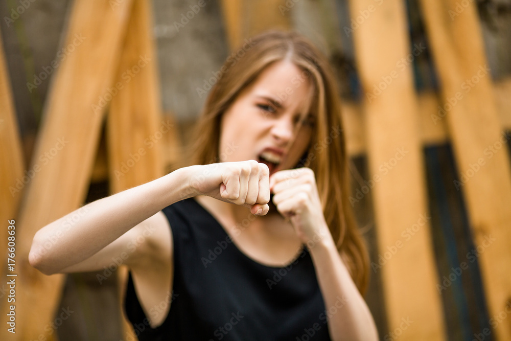 Attractive young woman boxing. Beautiful lady showing emotions of anger. Image with selective focus. Attractive young woman boxing. Beautiful lady showing emotions of anger. Image with selective focus.