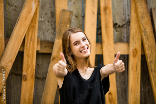 Happy beautiful woman showing thumbs up. Pretty girl with long hair smiling showing white teeth.