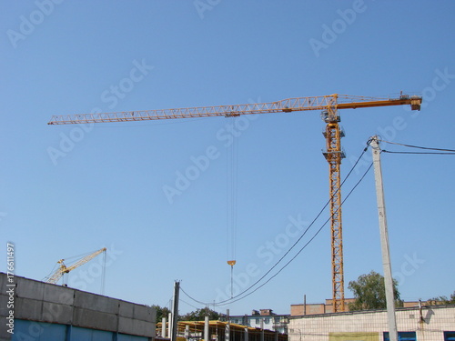 Abstract Industrial background with construction cranes silhouettes over amazing sunset sky