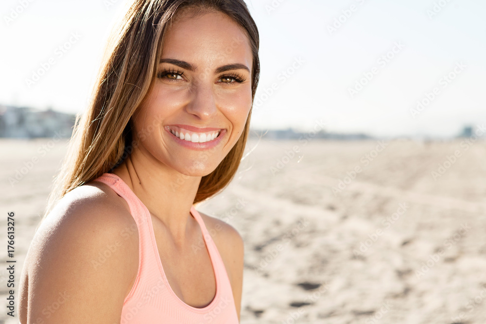 Naklejka premium piękna młoda kobieta uśmiecha się na plaży.