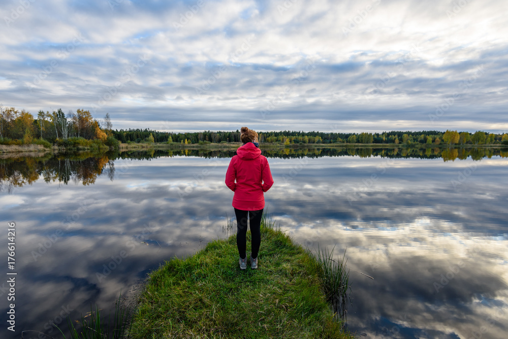 young woman in red jacket enjoying nature on dirt road. Latvia young woman in red jacket enjoying nature on dirt road. Latvia