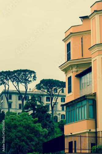  a residential area of ​​Rome with colorful green houses and parked cars in a cool, plentiful day