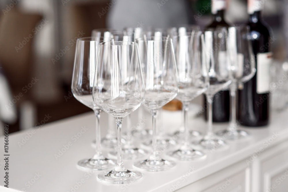Crystal clear empty wine glasses on the table. Alcohol background. A lot of wine glasses at the bar. Crystal clear empty wine glasses on the table. Alcohol background. A lot of wine glasses at the bar.