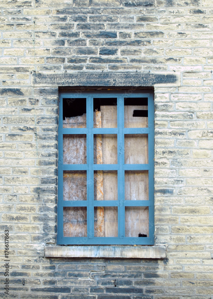 boarded up blue window in a derelict house with dirty brick wall boarded up blue window in a derelict house with dirty brick wall