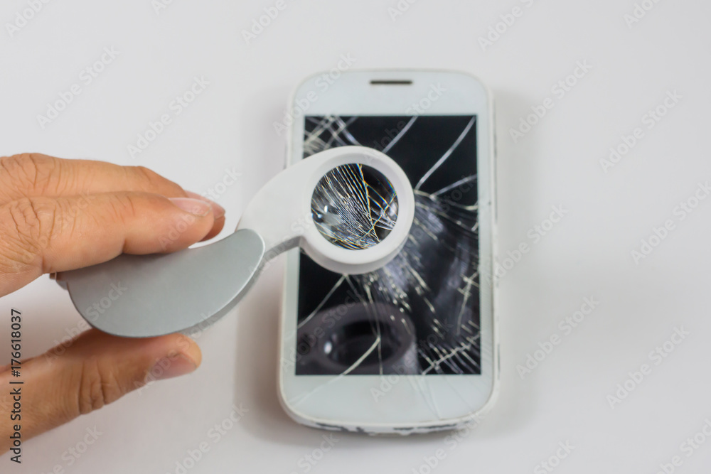 smart phone with broken screen and magnifier on white background