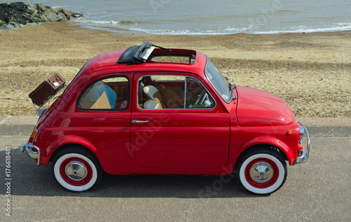  Classic Red Fiat 500  motor car with picnic basket parked on seafront promenade. photo