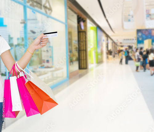 Female walks hands holding shopping bags and credit card in the mall