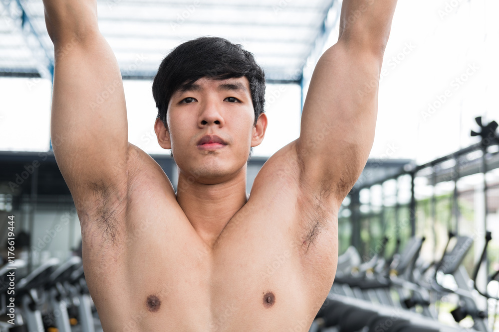 young man execute exercise with machine in fitness center. male athlete training in gym. sporty guy working out in health club. young man execute exercise with machine in fitness center. male athlete training in gym. sporty guy working out in health club.