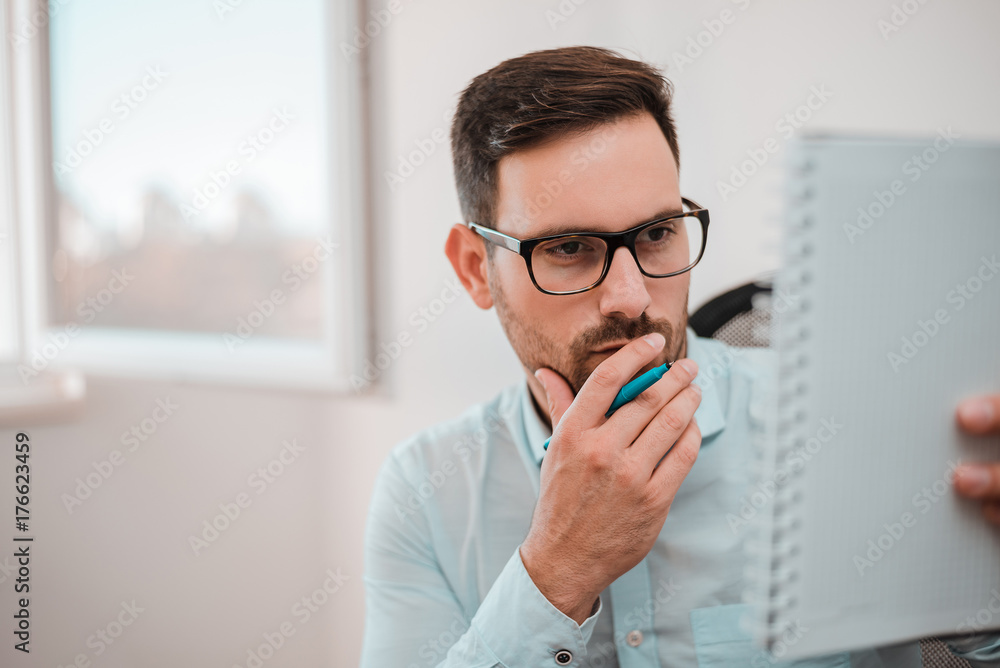 Handsome man doing some paperwork at home. Handsome man doing some paperwork at home.