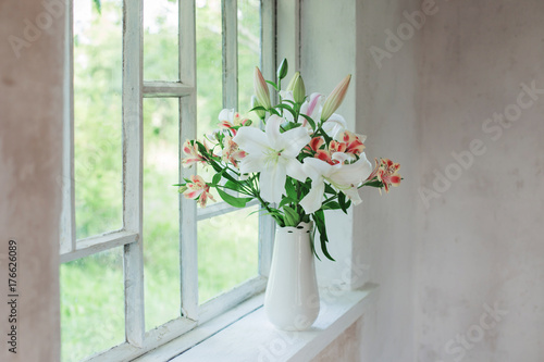 Fototapeta Naklejka Na Ścianę i Meble -  beautiful white lily in vase on windowsill