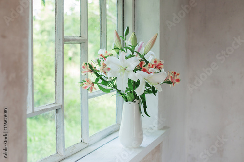 beautiful white lily in vase on windowsill